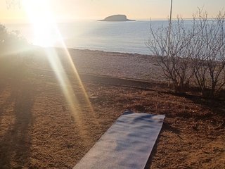 Amanecer en el embalse de Guadalest con una persona meditando en la orilla