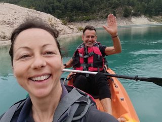 Grupo de kayaks navegando en silencio por el embalse rodeado de montañas verdes